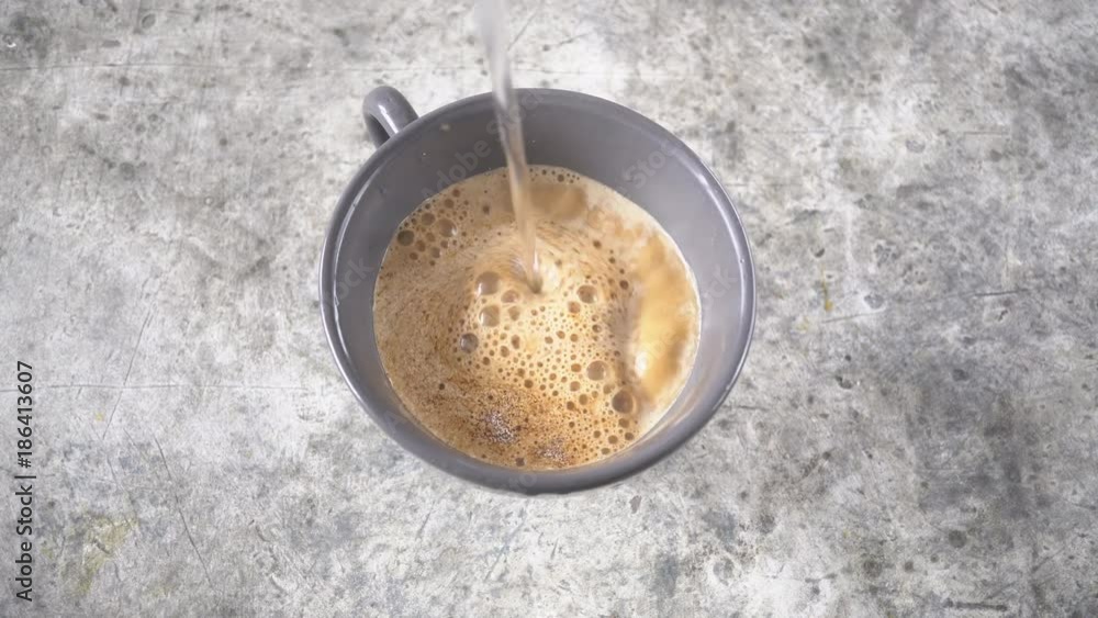 Pouring hot water into instant coffee, breakfast hot drink concept, top view Pouring hot water into instant coffee, breakfast hot drink concept, top view