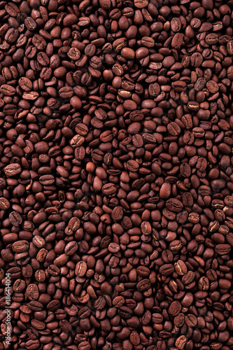 Coffee bean dark roasted scattered texture background photo vertical