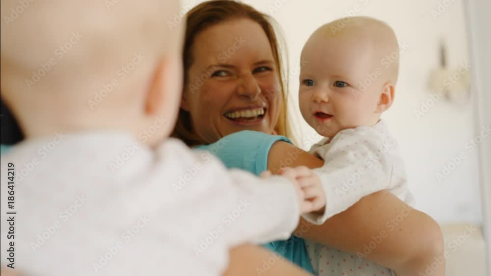 Mother and baby daughter at playing at home looking in mirror Mother and baby daughter at playing at home looking in mirror