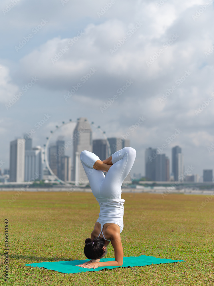 Asian chinese woman practising yoga outdoors in Singapore
