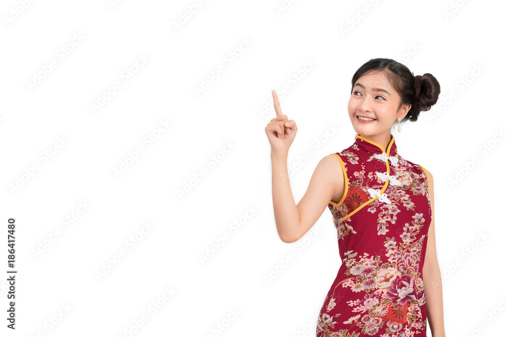 Asian woman wearing chinese dress,cheongsam,qipao finger gesture present and show something on copy space white isolated background and smile Asian woman wearing chinese dress,cheongsam,qipao finger gesture present and show something on copy space white isolated background and smile