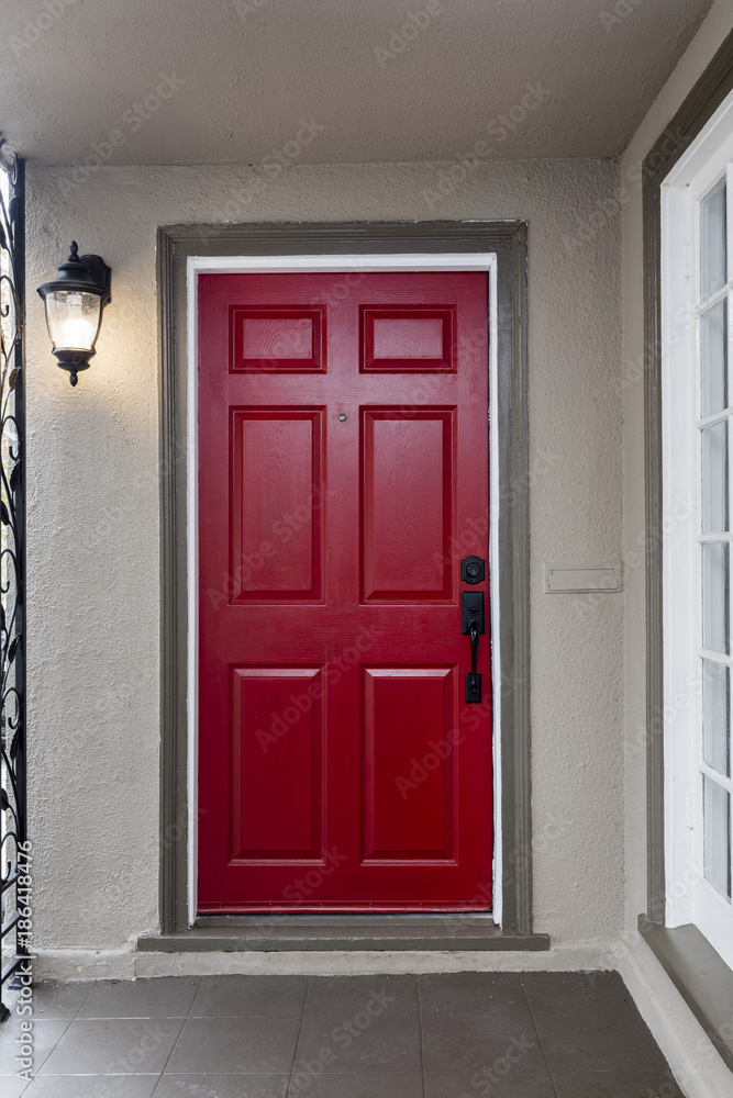 Fototapeta premium Red entry door / front door with door viewer and Venetian Bronze Single Cylinder Sectional Handleset.