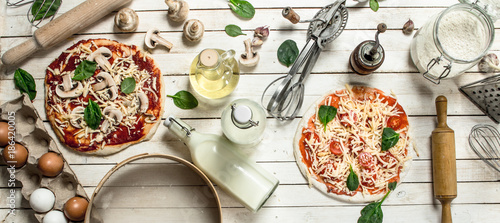 Preparation of pizza with various ingredients.