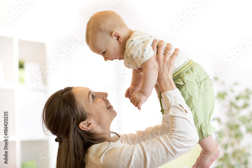 Happy mother raising baby a...
