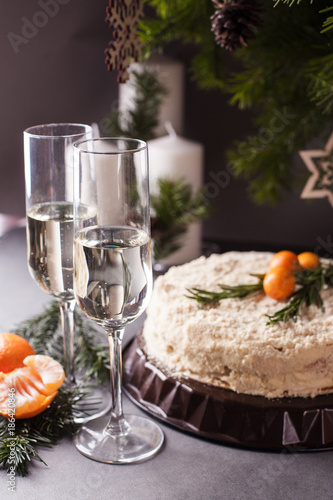 a festive New Year's table, cake, tangerines, champagne and two glasses