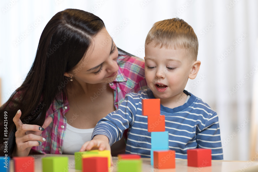 Child boy together with mother playing toys Child boy together with mother playing toys