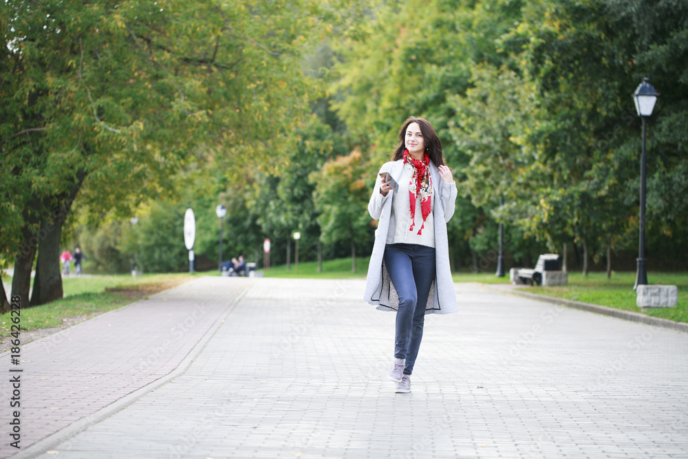 Portrait of happy young brunette woman in gray coat talking on the phone Portrait of happy young brunette woman in gray coat talking on the phone