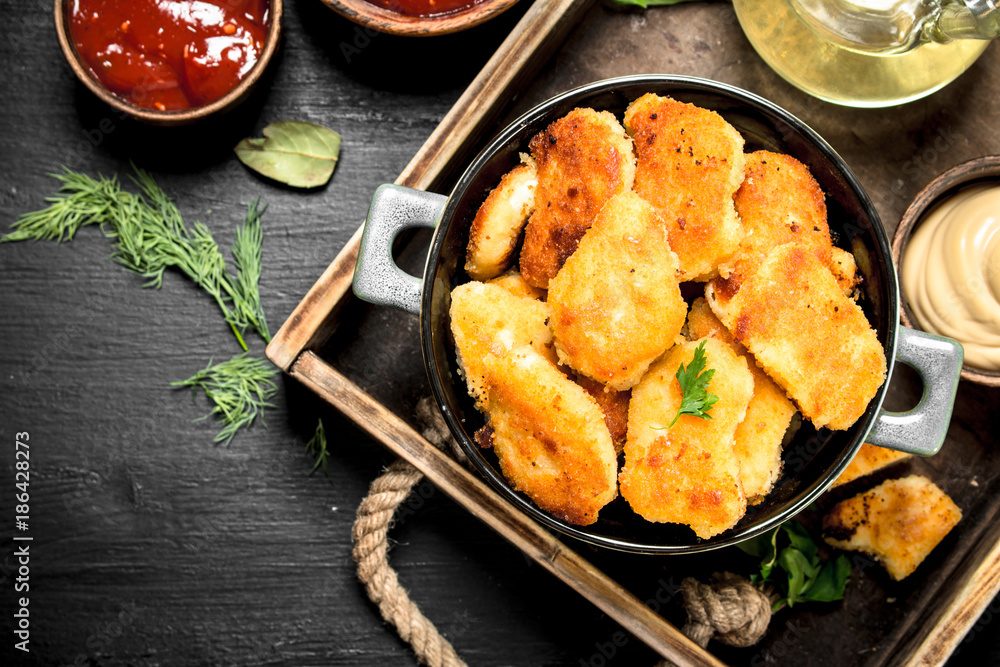 Nuggets from chicken meat with sauces on a tray. Nuggets from chicken meat with sauces on a tray.