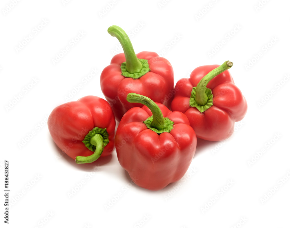 Still life with four whole red ripe bell peppers isolated on white background close up