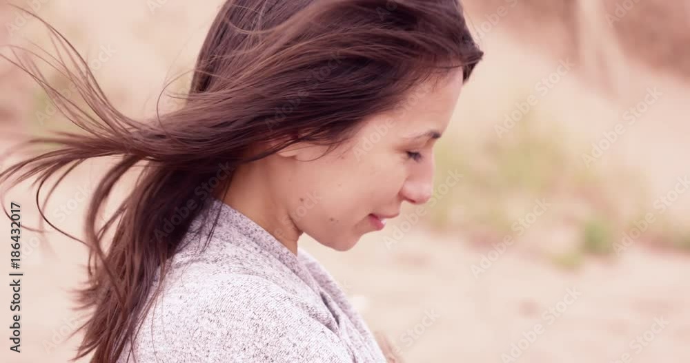 Beautiful women outdoors in wind smiling and being shy - warm colours Beautiful women outdoors in wind smiling and being shy - warm colours