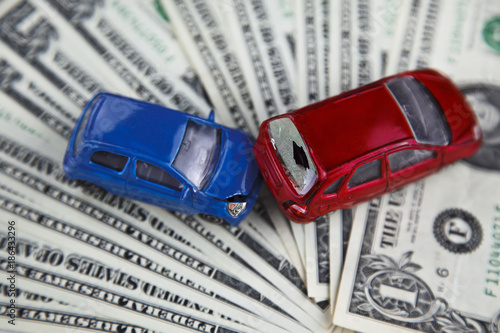 concept of car insurance, imitation collision, amid American banknotes, car accident