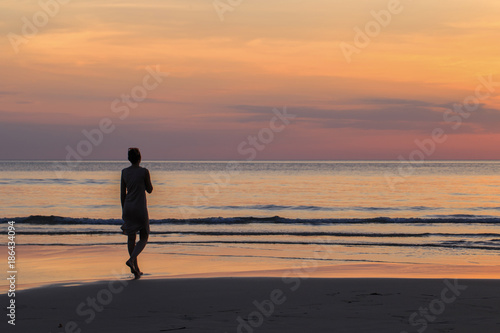 Men  Standing alone  Watching the sunset on the beach.  Evening time  Silhouette style