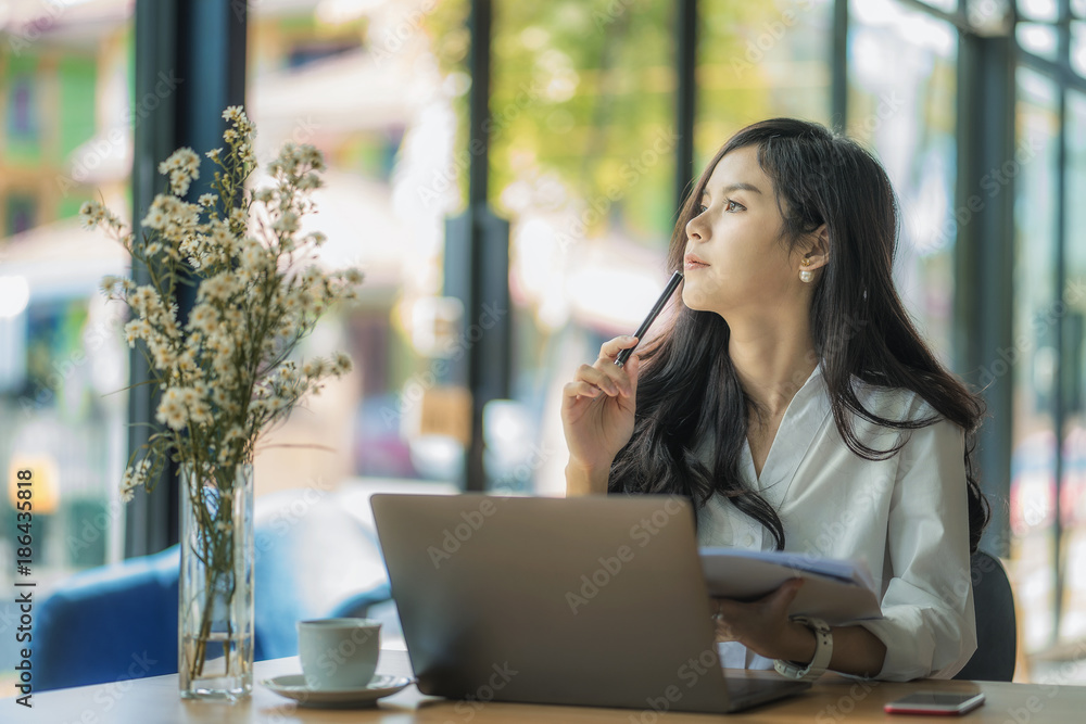 Young business woman using on the laptop while sitting at her working place. Young business woman using on the laptop while sitting at her working place.