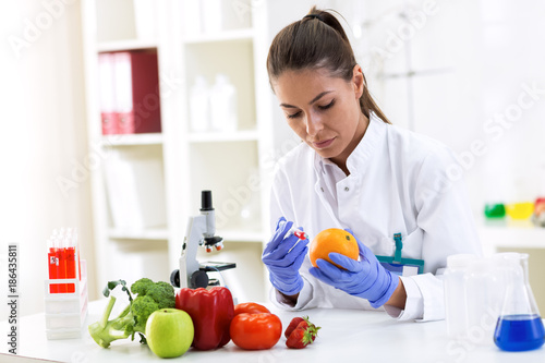 Scientist putting new sample to fruit and cheking results at clinic
