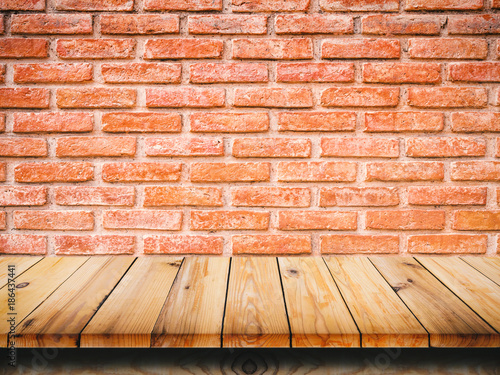 Wood table top on red brick wall