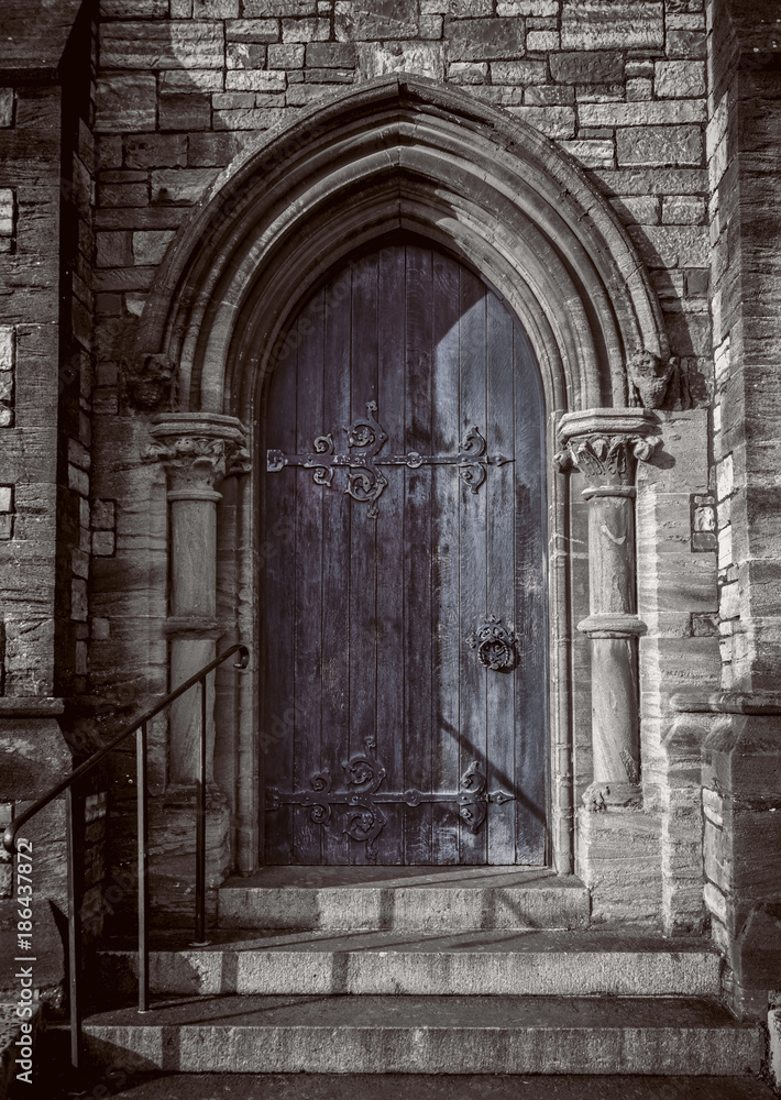 Close-up of traditional gothic medieval wooden entrance doorway with ancient brick arc, mystical portal Close-up of traditional gothic medieval wooden entrance doorway with ancient brick arc, mystical portal