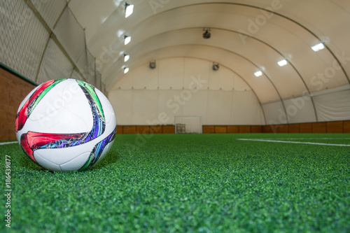 A football ball on an artificial grass in the hall