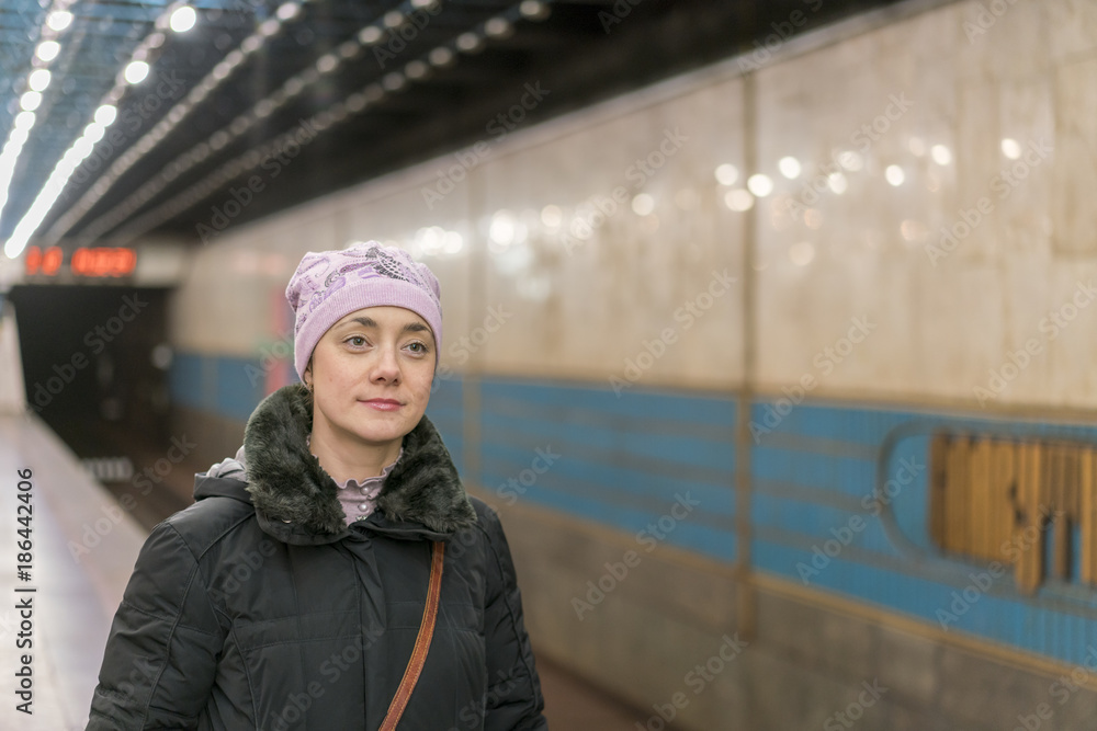 Woman waiting for the metro train on the station platform Woman waiting for the metro train on the station platform