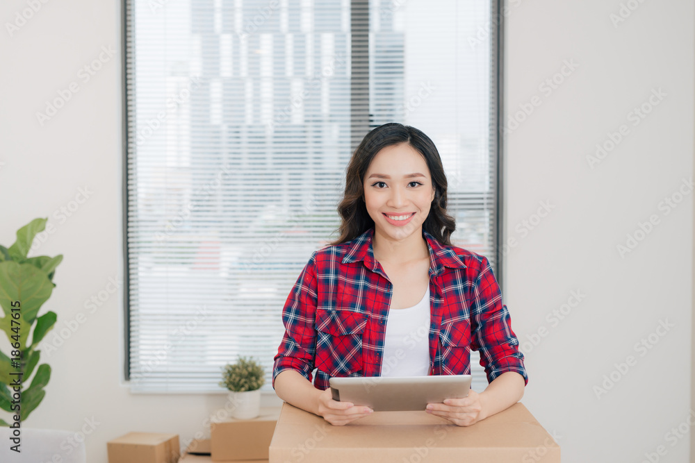 Portrait of happy woman using digital tablet during moving home Portrait of happy woman using digital tablet during moving home