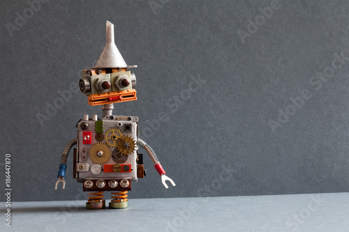 Creative design robot toy with metal funnel hopper, cogs wheels gears silver metallic body. gray background. Copy space