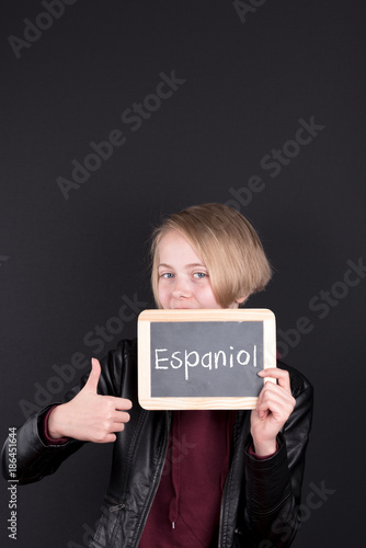Schulind mit einem Schild auf dem Espaniol steht photo