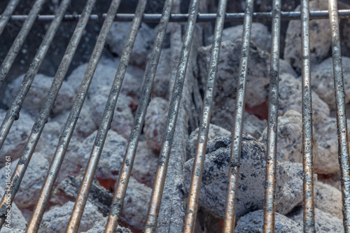 Barbecue grillage with hot coal briquets under it. No meat grilling. Closeup of the barbecue.