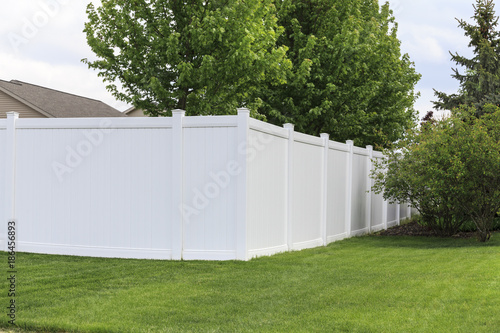 Contemporary white vinyl fence surrounding yard