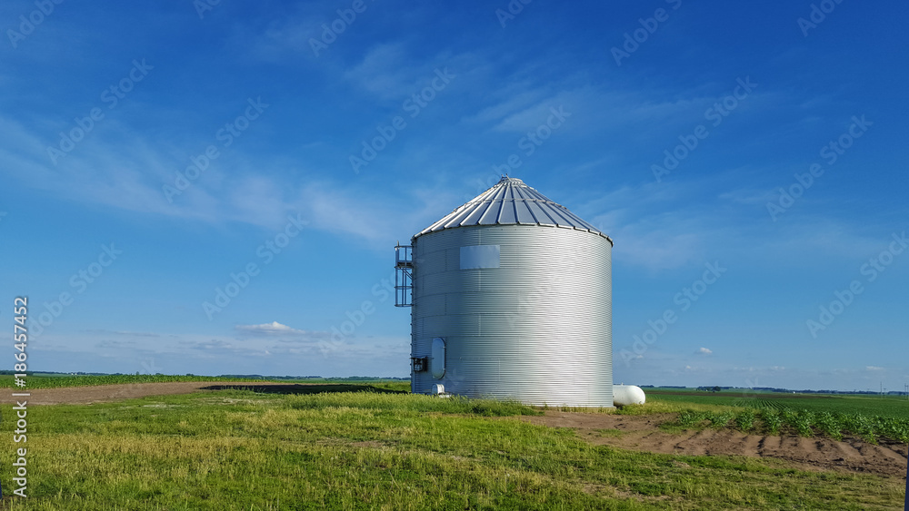 Metal silo on farmland in rural landscape Metal silo on farmland in rural landscape