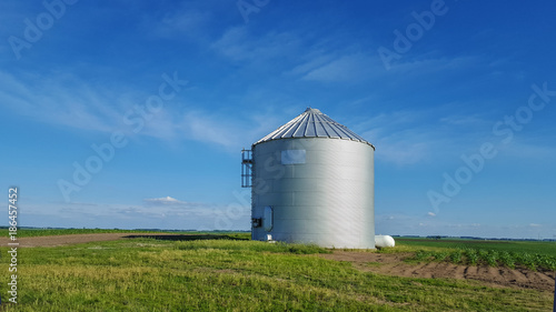 Metal silo on farmland in rural landscape photo