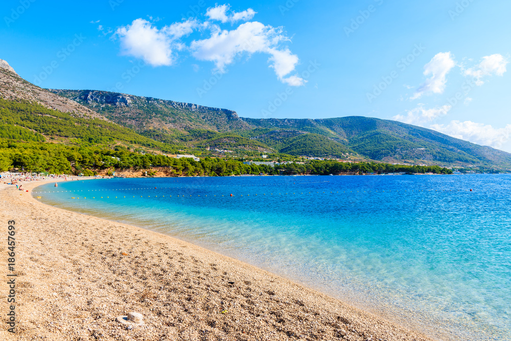 View of empty Zlatni Rat beach with beautiful sea water and mountains in background, Brac island, Croatia
