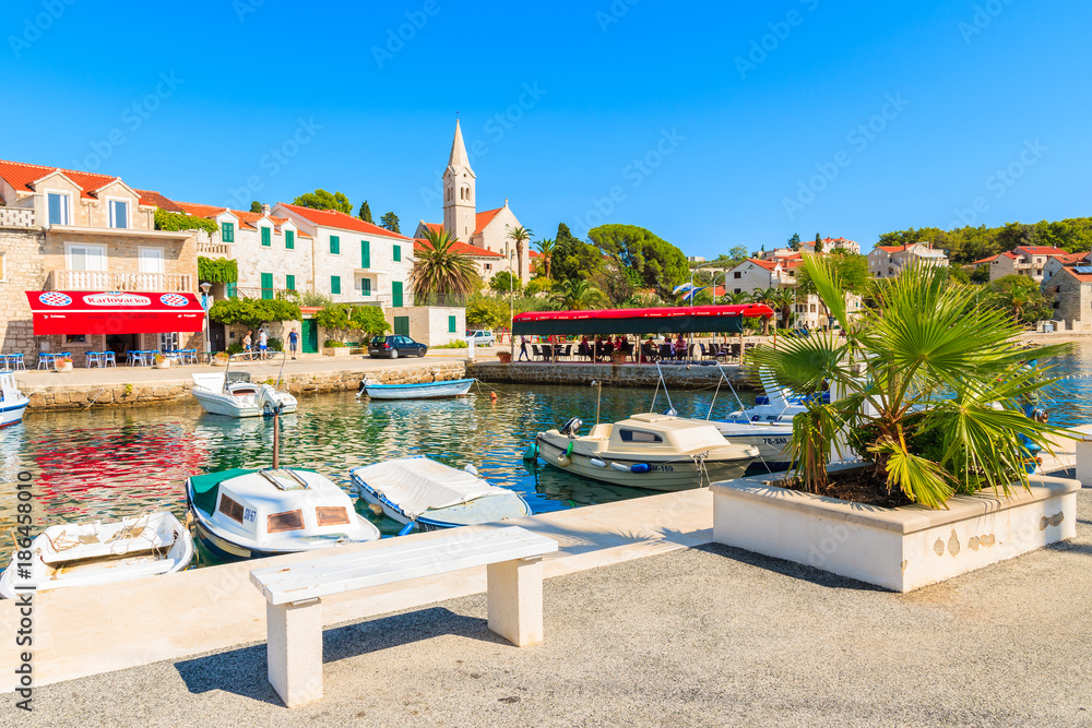 Naklejka premium SUMARTIN PORT, BRAC ISLAND - SEP 13, 2017: Typical fishing boats anchoring in Sumartin port on Brac island, Croatia.
