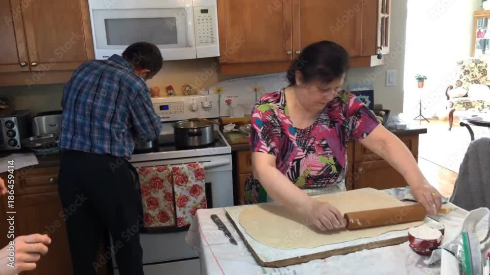 Older couple preparing food in home kitchen for baking