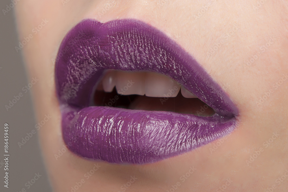 Foto Stock Lips with purple lipstick close-up | Adobe Stock