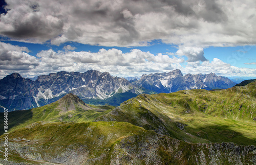 Gentle green slopes of Carnic Alps and jagged rock faces Sexten Dolomites with Monte Popera, Cima Undici, Croda Rossa di Sesto and Punta dei Tre Scarperi peaks, Belluno and South Tyrol, Italy, Europe