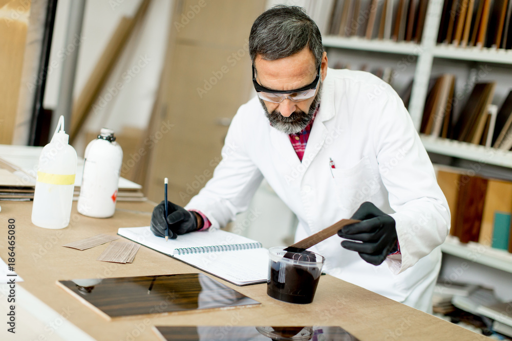 Handsome mature engineer working in laboratory in the furniture factory