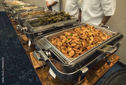Φωτογραφία large tray of shrimp and other dishes at a large catered banquet buffet