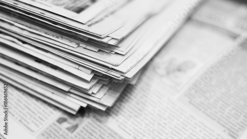 Lots of newspapers. Folded and stacked on top of each other. Selective focus