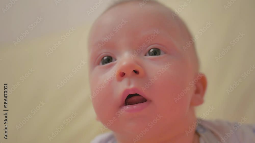 Little Baby Plays On The Floor. Close-up portrait view. Small smiling baby with a toy. Little Baby Plays On The Floor. Close-up portrait view. Small smiling baby with a toy.