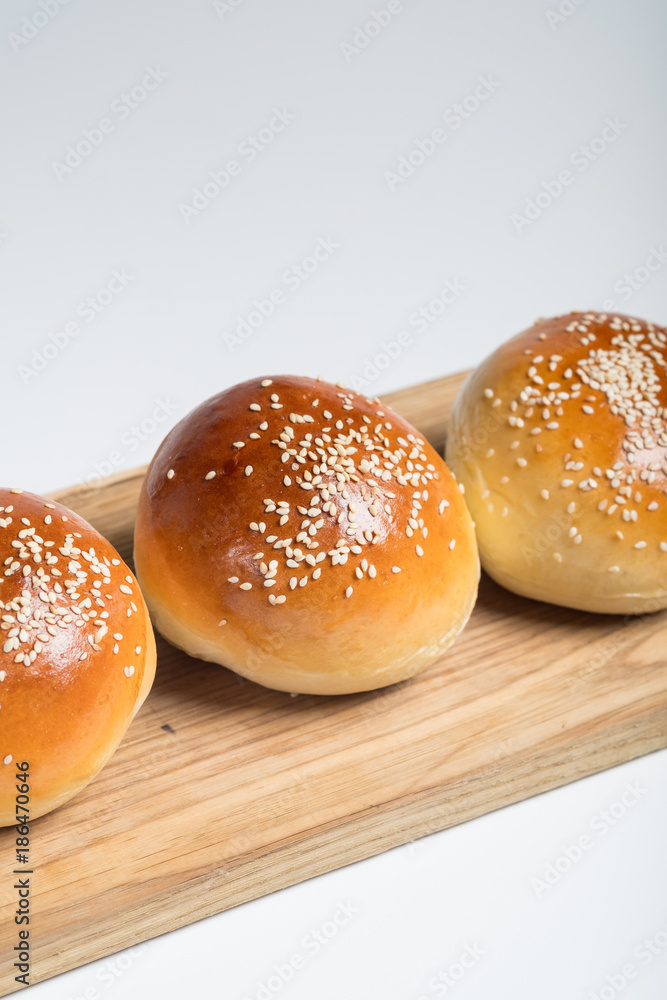 Cooking bread buns for burger on wooden table white isolated background.