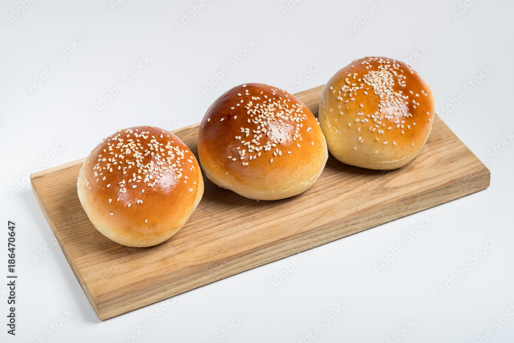 Cooking bread buns for burger on wooden table white isolated background. Cooking bread buns for burger on wooden table white isolated background.