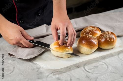 Cooking fresh hamburger buns with sesame seeds. Delicious butter cakes. Fast food concept.