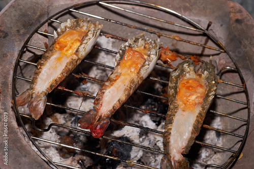 closeup river prawn and cut back with orange egg grilled by charcoal on grill.