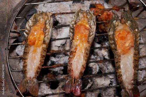 closeup river prawn and cut back with orange egg grilled by charcoal on grill.