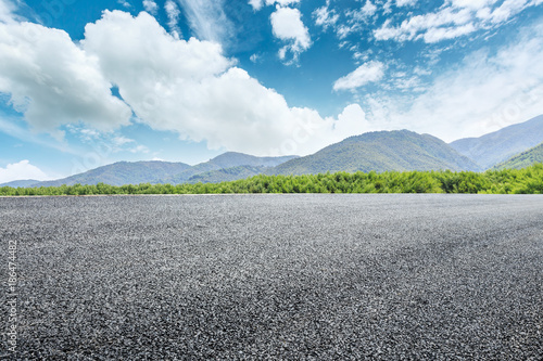 country road and mountains with forest in summer