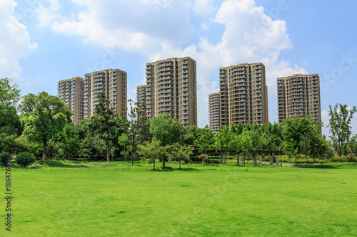 Fototapeta Naklejka Na Ścianę i Meble -  urban suburban apartment buildings and green park lawn