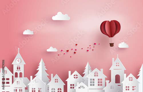 Illustration of Love and Valentine Day,Paper hot air balloon heart shape floating on the sky over village , Paper art and craft style..