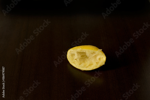 Squeezed lemon skins on dark background - lemon peel - dark food photography, copy space