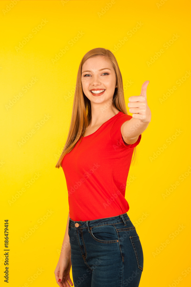 Beautiful young woman with too big trousers and scale gesture a weight loss over yellow background Beautiful young woman with too big trousers and scale gesture a weight loss over yellow background