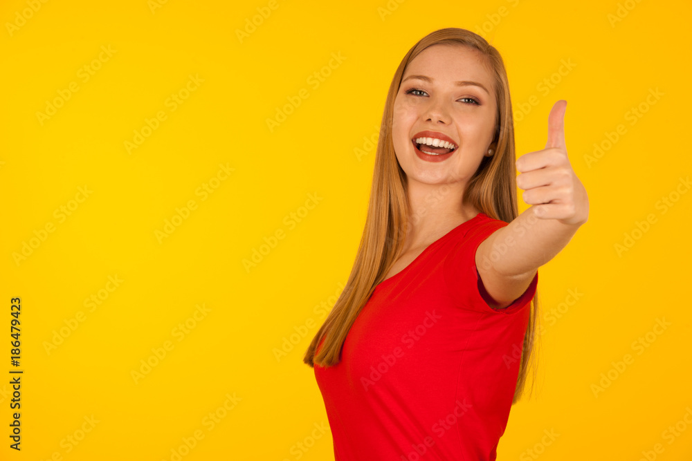 Beautiful young woman with too big trousers and scale gesture a weight loss over yellow background Beautiful young woman with too big trousers and scale gesture a weight loss over yellow background