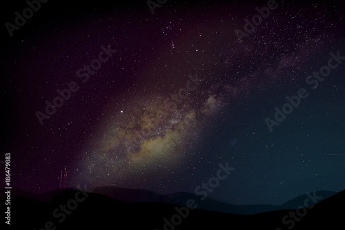 dramatic starry night sky with mountains below photo